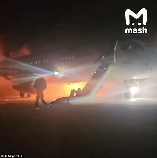 Passengers held on to their belongings as they used an inflatable emergency slide to escape the inferno