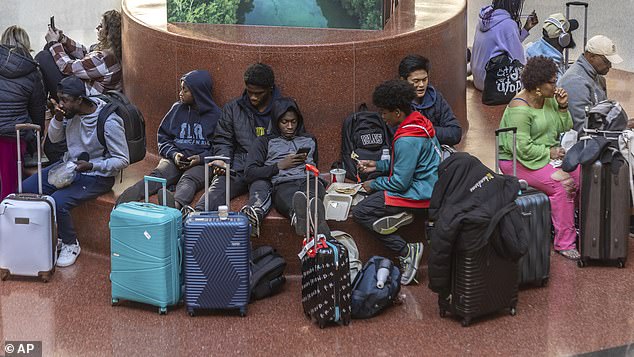 Travelers wait at Hartsfield-Jackson International Airport, Friday, Nov. 22, 2024, in Atlanta, as the Thanksgiving travel season kicks off