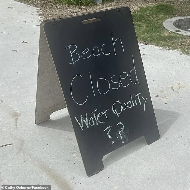 A volunteer lifesaver removed human feces from the beach, but this did not stop some swimmers from entering the water. Pictured is a closed sign on the beach