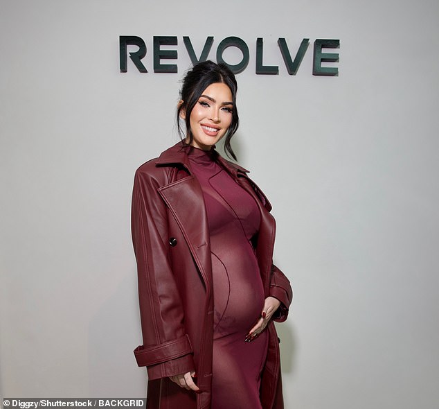 The burgundy dress was paired with sky-high black heels and a matching leather jacket - with the star cradling her bump on the red carpet