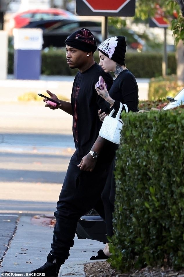 She accessorized her casual ensemble with a beanie with graffiti letters on the front, a quilted white handbag and fluffy slippers.