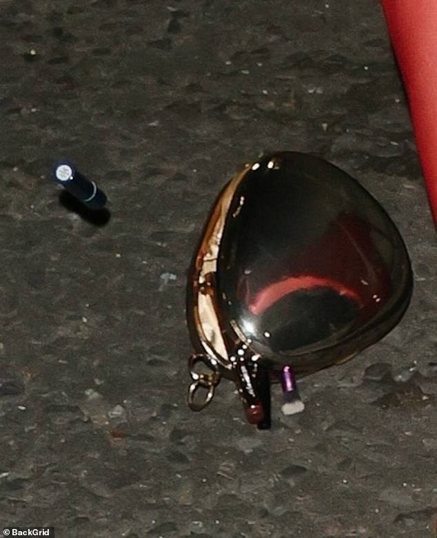 Jess' metal heart-shaped bag fell from the strap and hit the ground, as its contents, including her make-up, fell out and were scattered across the street.