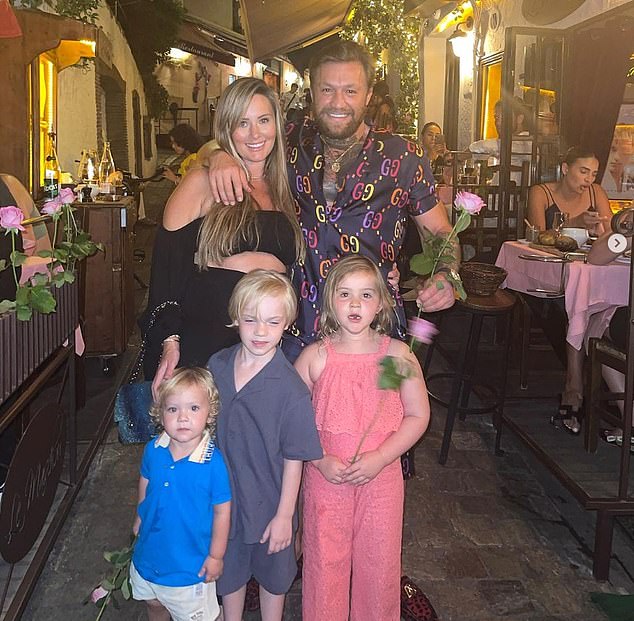 Devlin and McGregor are pictured above on holiday with their children while Devlin was pregnant with their fourth child