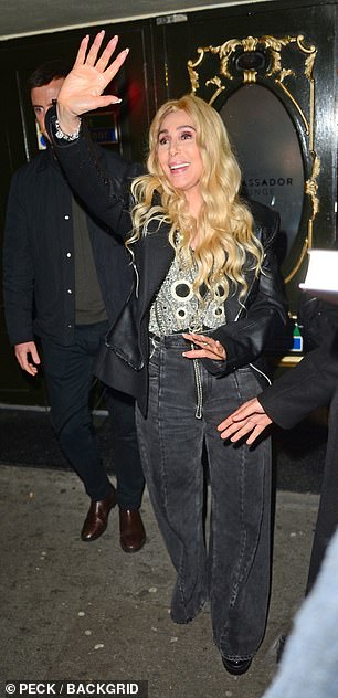 Cher cut a stylish figure in a black leather jacket, flared jeans and a silver-embellished top