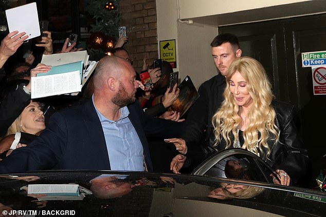 A huge crowd of fans had gathered at the stage door with copies of Cher's memoirs to sign