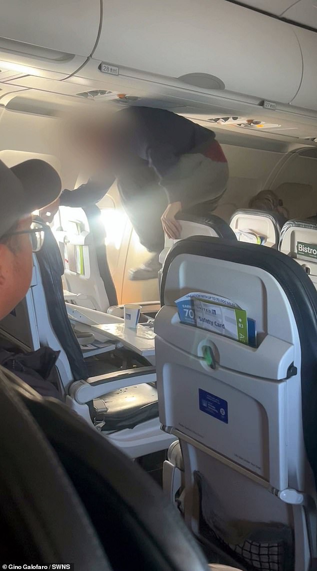 The person can be seen holding both an aisle seat and an exit seat while kicking the center seat with enough force to knock it back into the row behind it.