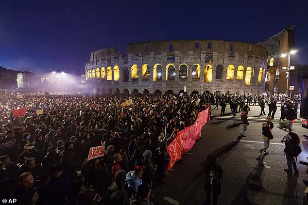 People take part in a gathering ahead of the International Day for the Elimination of Violence against Women, in front of the Colosseum in Rome, Saturday, November 23, 2024