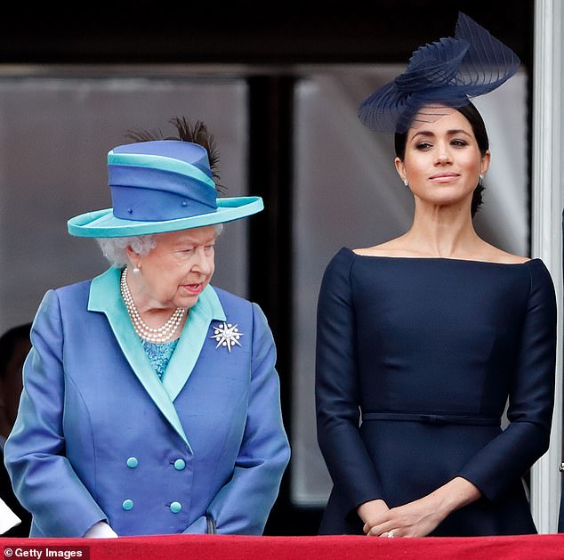 Queen Elizabeth II and Meghan watch a flypast from the balcony of Buckingham Palace to mark the centenary of the Royal Air Force on July 10, 2018