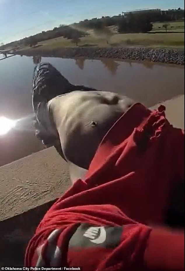 The man was seen starting to roll onto his side, but just as he was about to plunge into the water below, the officer reacted in the nick of time and barely grabbed the man by the sweatshirt to hoist him back onto safer ground.