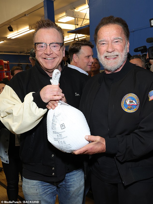 Wearing a casual all-black look before the holidays, Arnold showed his patriotism in a black bomber jacket with an American flag patch on one sleeve and a California flag on the other.