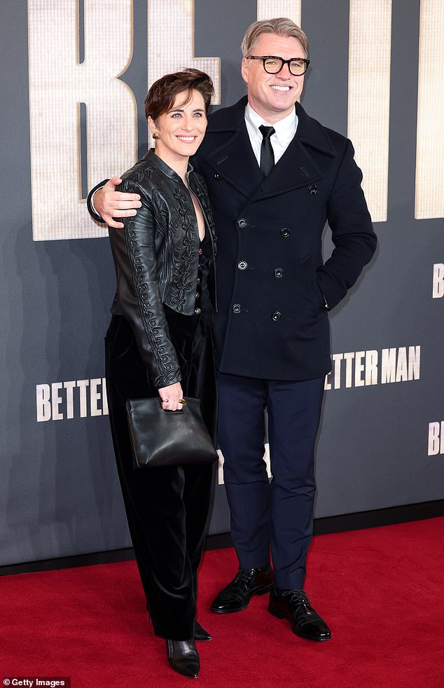 Vicky posed next to her filmmaker-producer boyfriend Jonny, 52, who looked dapper in a crisp white shirt, black tie and trousers, layered under a double-breasted jacket