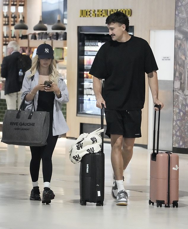 Ivan cut a similarly relaxed figure in black shorts and a dark T-shirt as he wheeled several large suitcases behind him