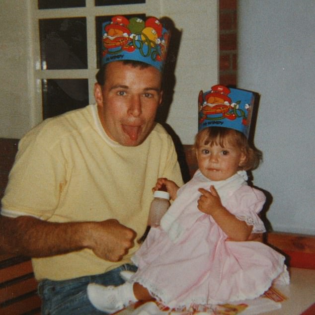 Little Coleen wears a paper hat as she poses with her dad