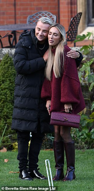 She wore Van Cleef earrings and carried her essentials in a burgundy bag as she posed next to Harry, 31