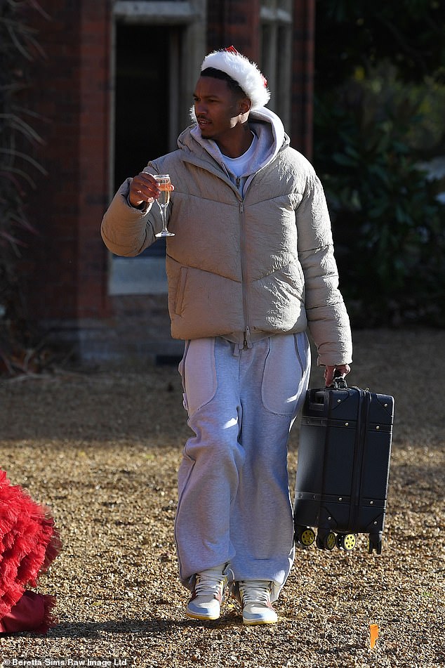 Roman, 21, kept warm in a gray puffer jacket and joggers as he pulled out his suitcase and sipped a glass of champagne