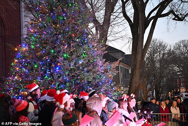 Members of the first family watch as a children's choir performs in the center of town