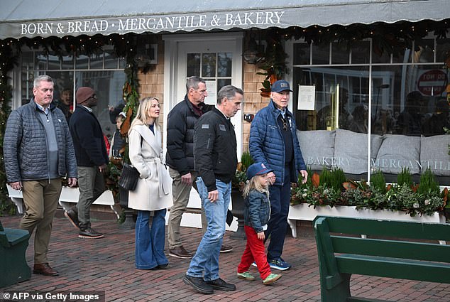 Biden strolled the shops, holding hands with his grandson Beau and petting a dachshund, as pedestrians looked on and shouted 'we love you, Joe'