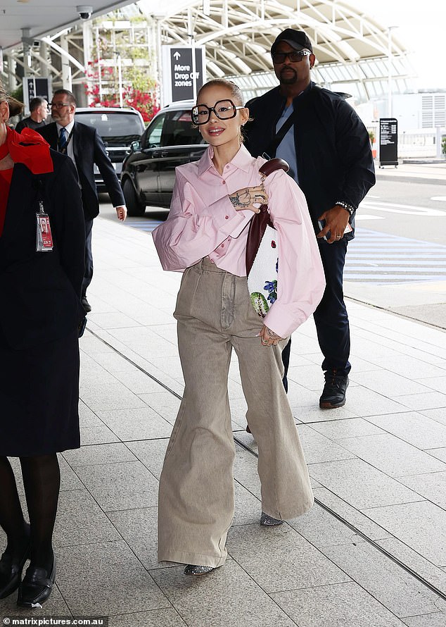 Ariana Grande cut a quirky figure as she prepared to take off from Sydney Airport on Tuesday