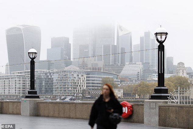 Another foggy day in London yesterday, as a woman walks along the River Thames