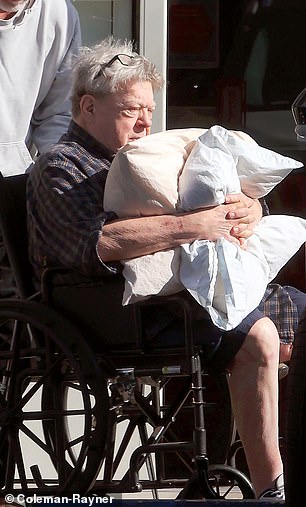 The television star, 76, was seen hugging two pillows as he was pushed in a wheelchair after visiting a dialysis clinic in Sherman Oaks, exclusive photos from DailyMail.com reveal.