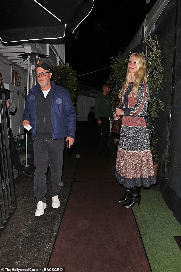 The supermodel, 54, wore a boho-inspired, midi-length blue and red dress with black boots as she left the restaurant as a photographer with her husband