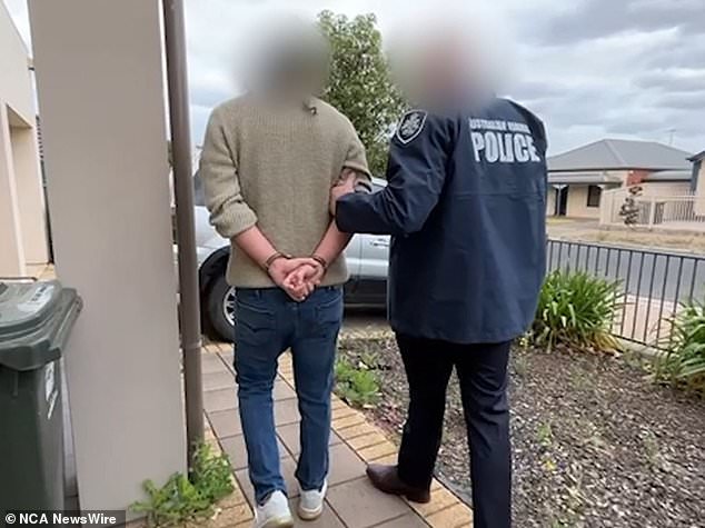 The man is said to have helped members of the youth group from Venezuela to migrate to Australia (pictured, the man is arrested at a house in Kilburn, Adelaide on Thursday)