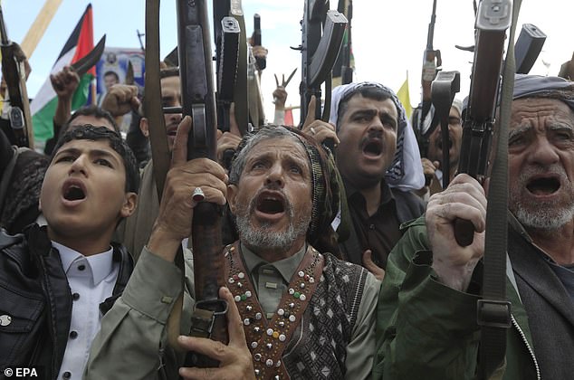 Houthi supporters chant slogans while raising their weapons during an anti-US and anti-Israel protest in Sana'a, Yemen, on November 22