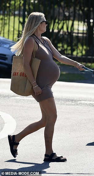 For the outing, Elyse cut a stylish figure in an olive tank dress that hugged her baby bump