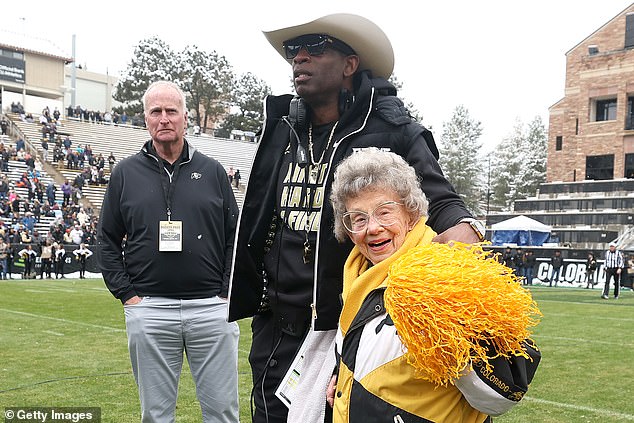 Head coach Deion Sanders of the Colorado Buffaloes stands with then 98-year-old fan Peggy Coppom in 2022. Coppom turned 100 years old on Tuesday in Boulder