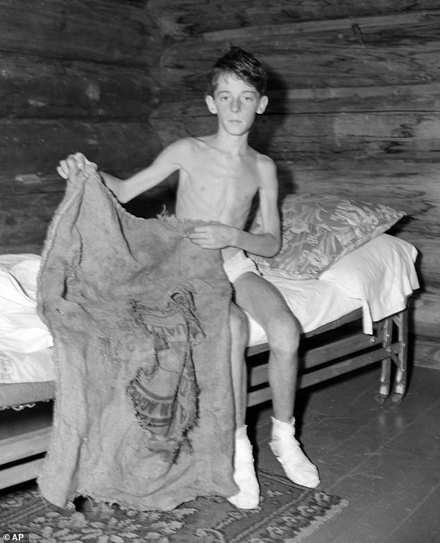 A skinny Donn Fendler, 12, from Rye, New York, is shown with the bag he used as a sleeping bag in the Maine wilderness as he lost 15 pounds