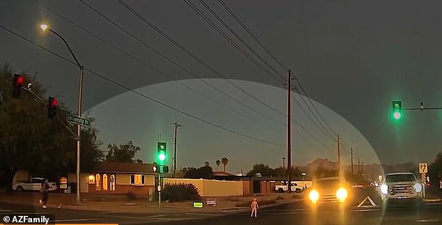 A small toddler wearing only a diaper was filmed walking into oncoming traffic at a busy intersection in Arizona