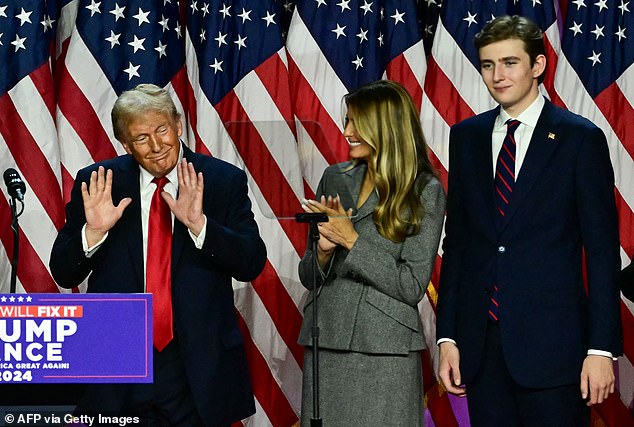 Barron, right, towers over his parents, pictured here as Donald Trump celebrated his historic victory on election night earlier this month