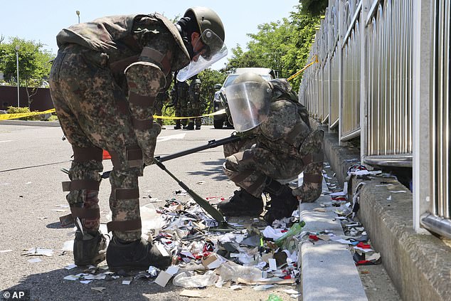 South Korean soldiers, dressed in protective gear, check waste from a balloon believed to have been sent by North Korea, in Incheon, South Korea, on June 2, 2024