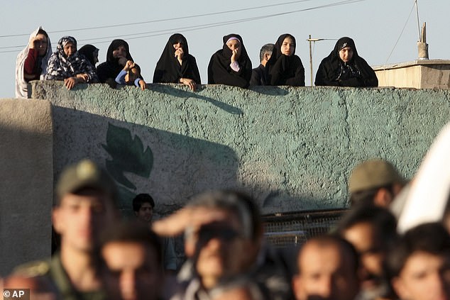 Under Iranian Sharia law, a victim's family can ask for blood money to spare the perpetrator's life, or also decide to forgive. Pictured: Local people watch as a hanging is carried out