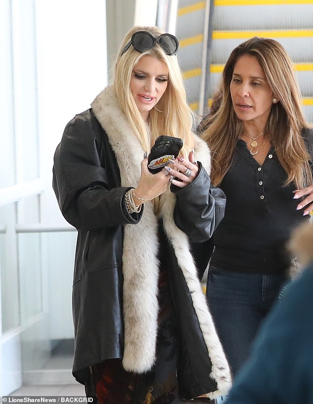 Jessica Simpson was spotted at LAX looking happy as she took a selfie with a friend