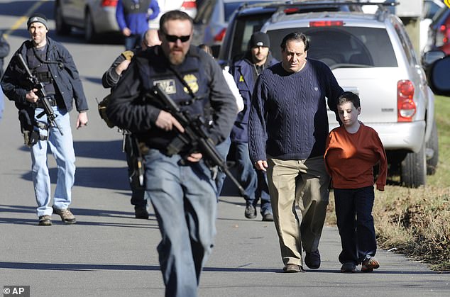 In this Dec. 14, 2012, file photo, parents leave a staging area after being reunited with their children following a shooting at Sandy Hook Elementary School in Newtown