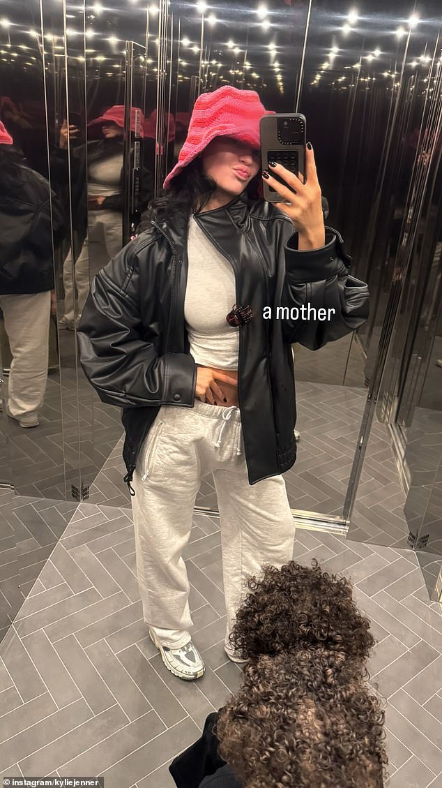 Kylie Jenner, 27, enjoyed sharing a selfie with her kids in a photo posted to social media on Sunday. The reality star showed off her toned stomach in sweatpants with a turtleneck crop top in a photo labeled 