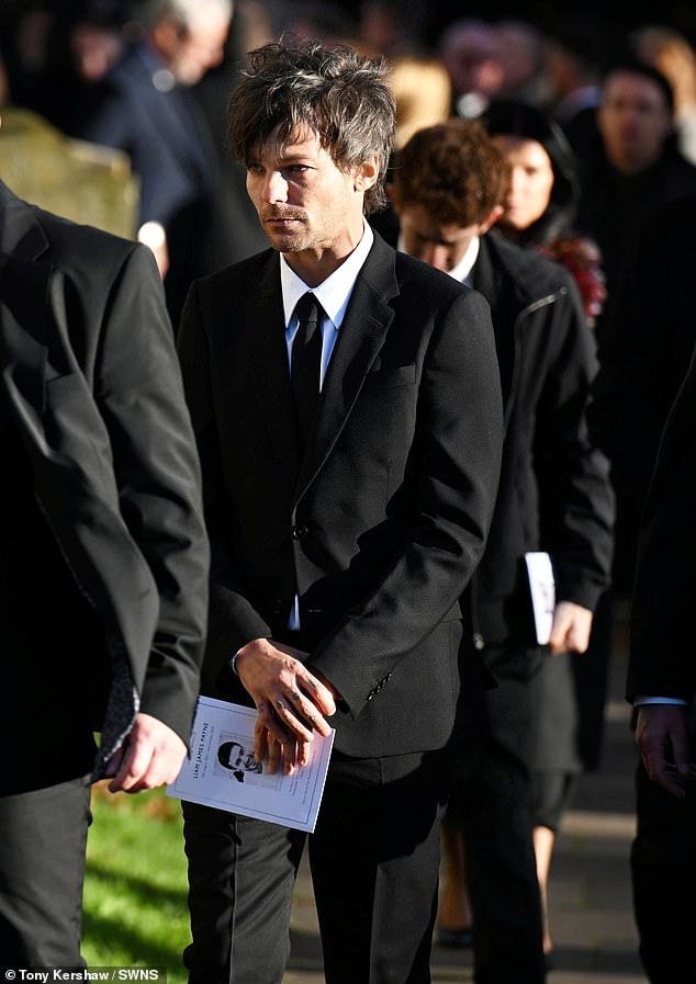 Louis Tomlinson leaves the church today with an order of service after the funeral