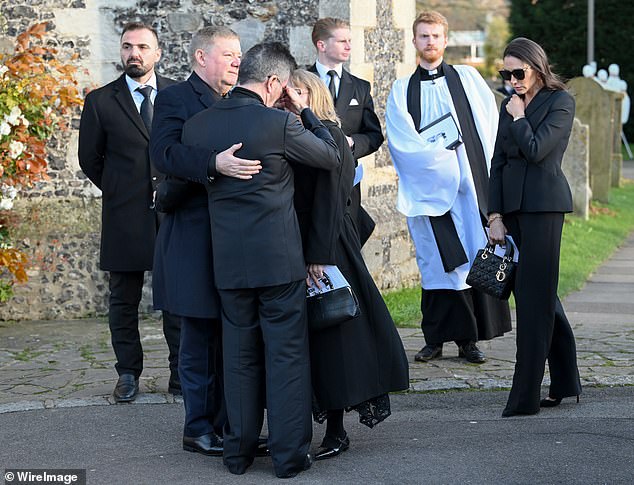 Simon Cowell is comforted by Liam Payne's father Geoff Payne (left) after the funeral today.