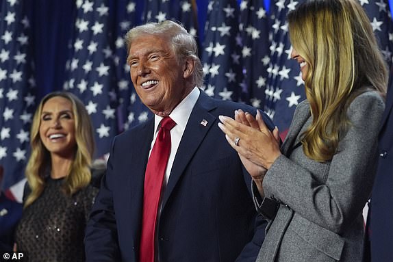 Republican presidential candidate, former President Donald Trump, stands on stage with former first lady Melania Trump, as Lara Trump looks on, during an election night watch party at the Palm Beach Convention Center, Wednesday, Nov. 6, 2024, in West Palm Beach, Florida. (AP Photo/Evan Vucci)