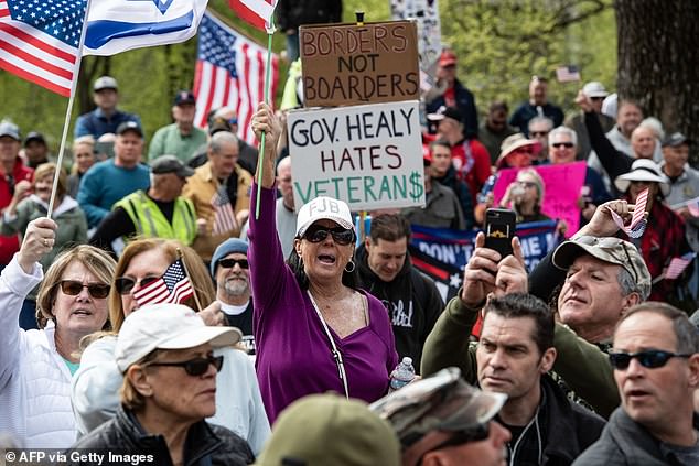 People hold signs and flags during a 'Close the Border' rally in Boston, Massachusetts, on May 4, 2024