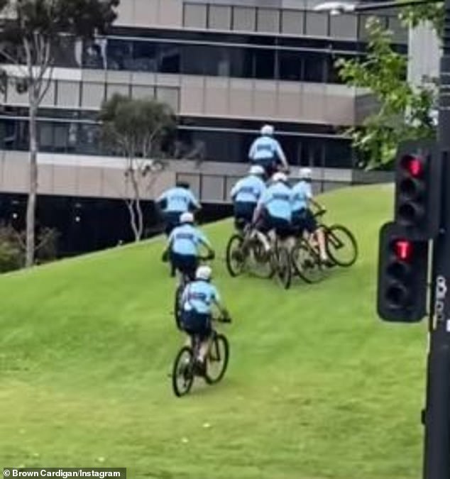 A police officer has been caught falling off his bike as he and his fellow officers tried to cycle up a hill during a training exercise (pictured)