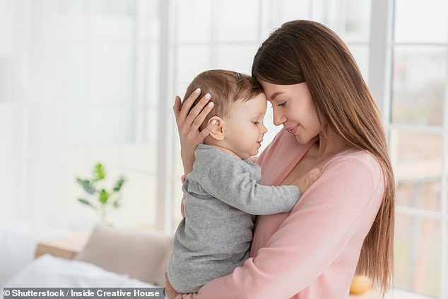 Stock photo of a young mother hugging and embracing her little child with love and care