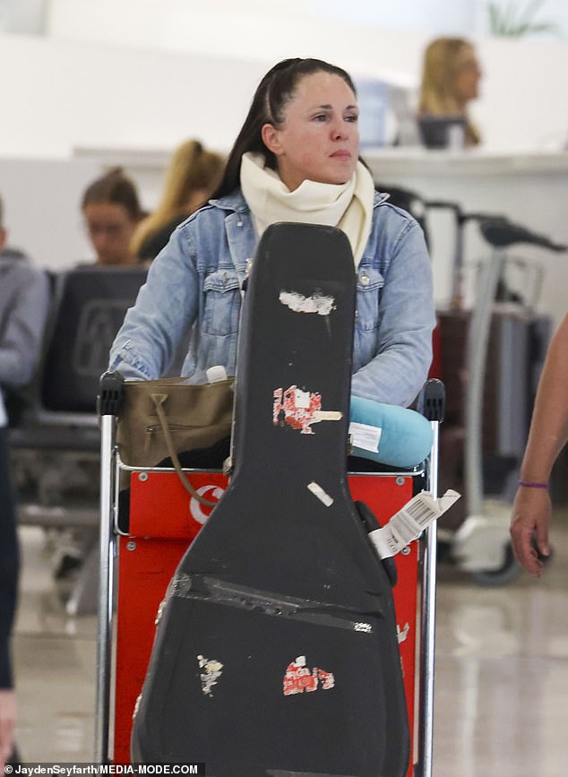 She finished her look with gray sneakers and a large white scarf around her neck