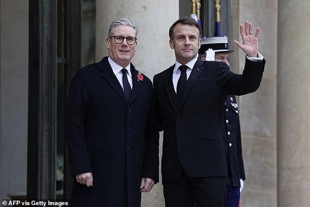 French President Emmanuel Macron (R) waves flanked by British Prime Minister Keir Starmer as he arrives at the Elysee Presidential Palace in Paris, November 11, 2024