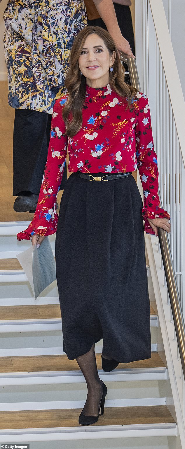 She wore a silk blouse with floral print by Erdem Lindsay Hideko that she tucked into a black maxi skirt with a belt, which showed off her slim figure.