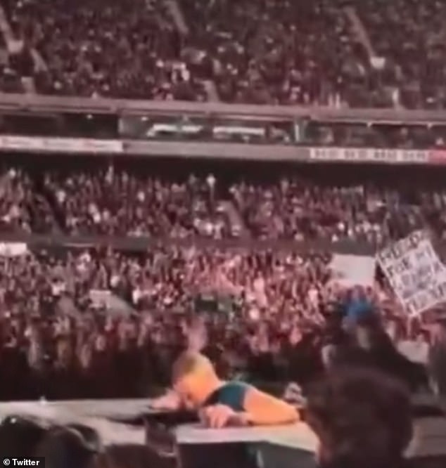 The Coldplay frontman was reading audience signs and walking backwards during a break in the show when he tumbled through a hole in front of the shocked audience. Pictured