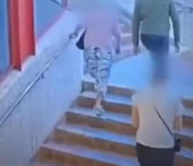 The pair were seen halfway up a flight of stairs in the train station, before the man (above right) grabbed the older women (above left).