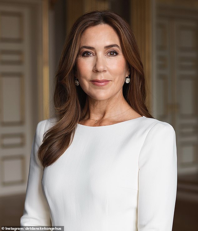 Queen Mary poses in an elegant cream boat-neck dress and diamond earrings - with a delicate 'F' necklace around her neck