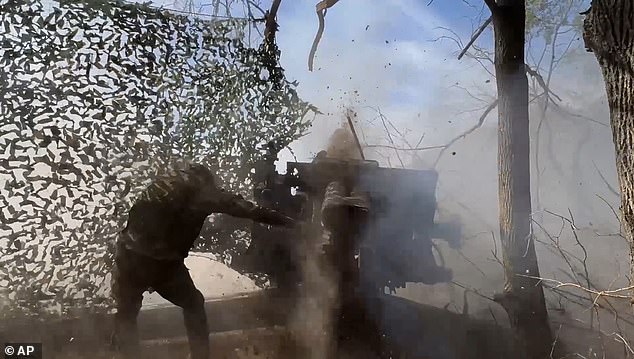 A Russian soldier fires from a howitzer towards the Ukrainian position in the Russian-Ukrainian border area in the Kursk region